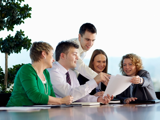 Groupe d'employés discutant autour d'une grande table de réunion.