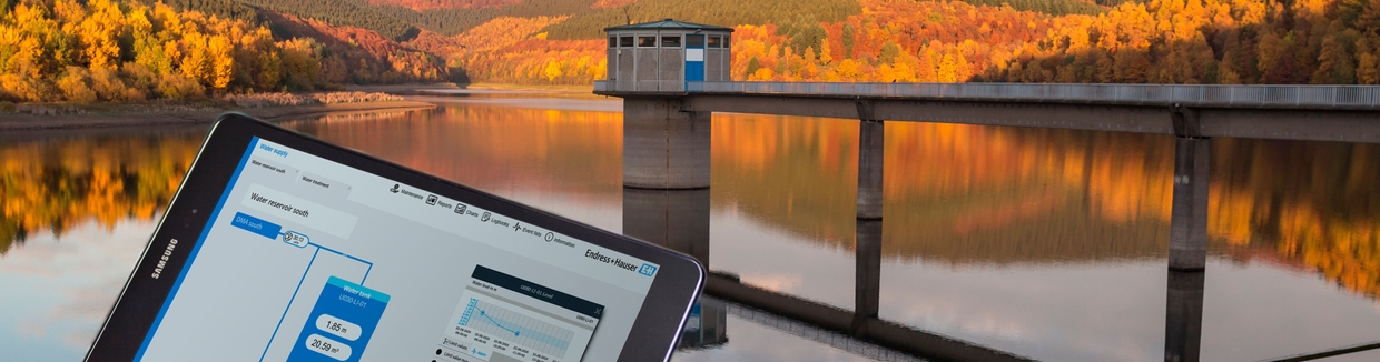 Dashboard of Netilion Network Insights in front of a water reservoir
