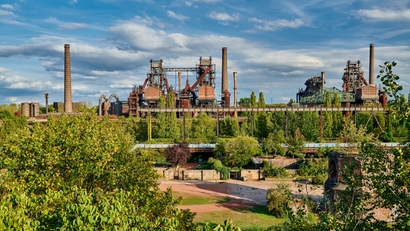 Aciérie au milieu d'un paysage de verdure.