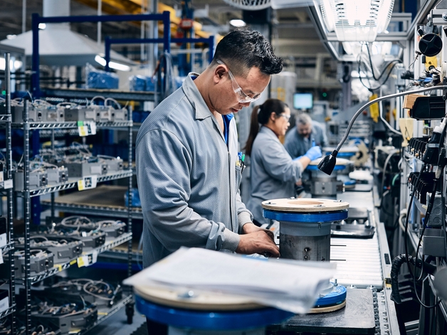 Production worker assembling a measuring device.