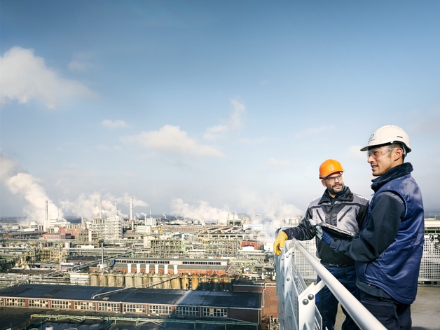 Deux ingénieurs regardent une grande installation industrielle.