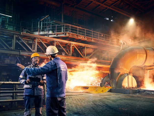 Two engineers discussing in a metal factory.