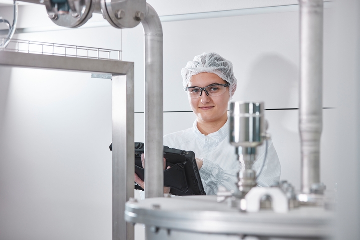 Woman with tablet in a hygienic factory environment